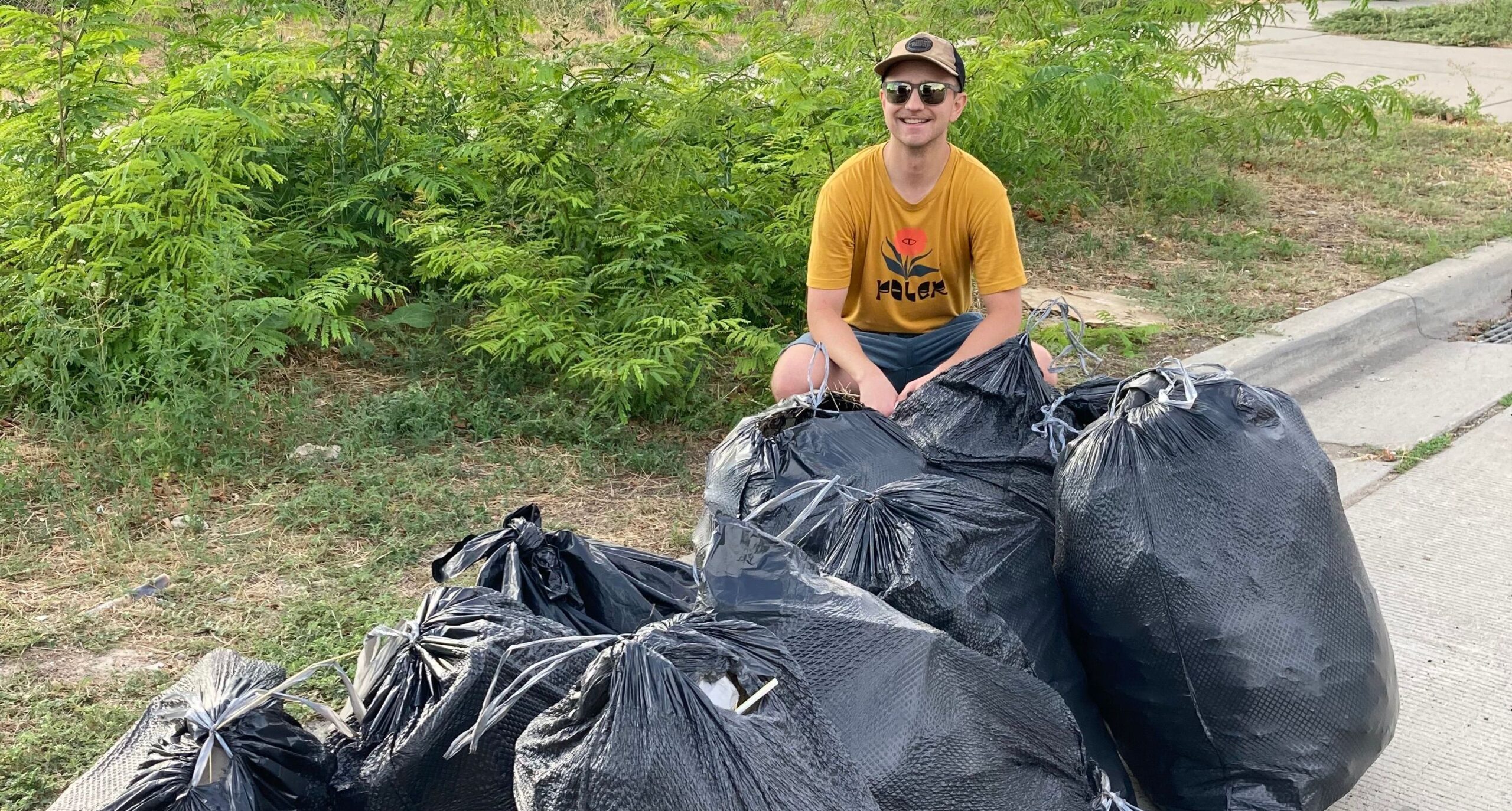 Ryland Hosenfield sits near bags of trash. His family is continuing his cleanup legacy
