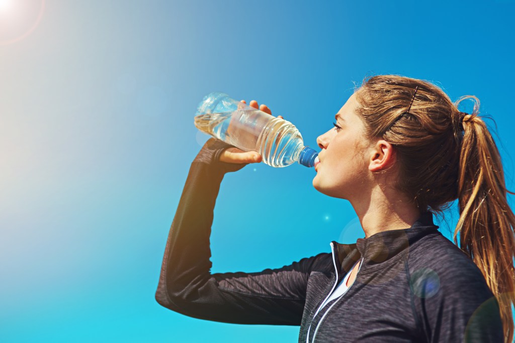 Woman chugging water bottle